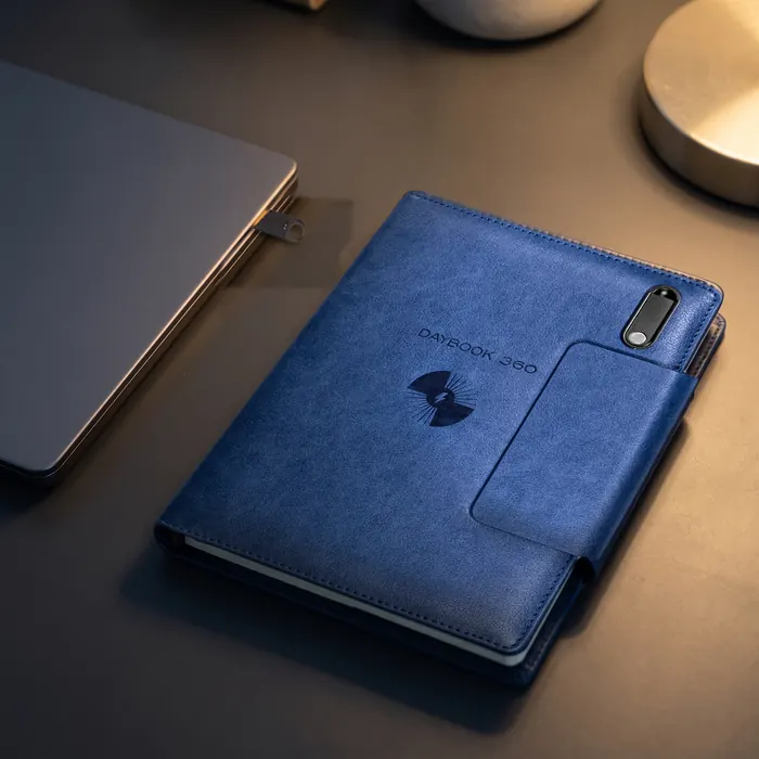 Illustration: the 64 GB USB drive from the navy DAYBOOK 360 plugged into a laptop’s USB-A port, the closed planner beside it with its empty drive slot
